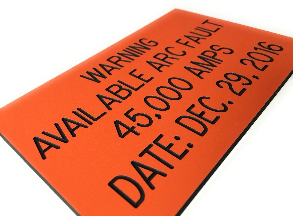 Close-up of custom engraved phenolic label showing depth of engraving — warning available arc fault 45,000 amps